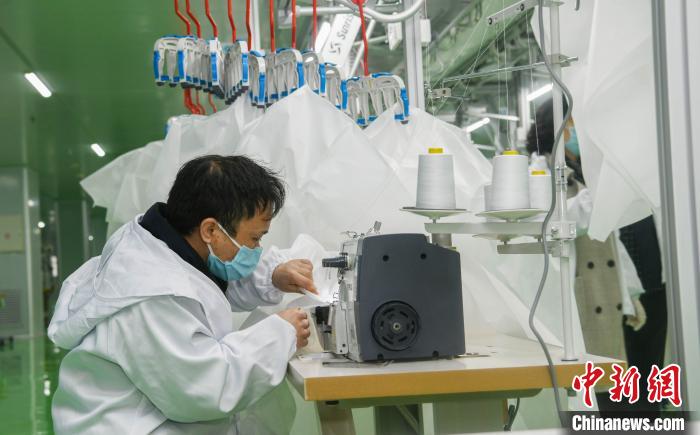 工人生產(chǎn)防護服，保障抗疫物資供應(yīng)。廣安市委宣傳部供圖