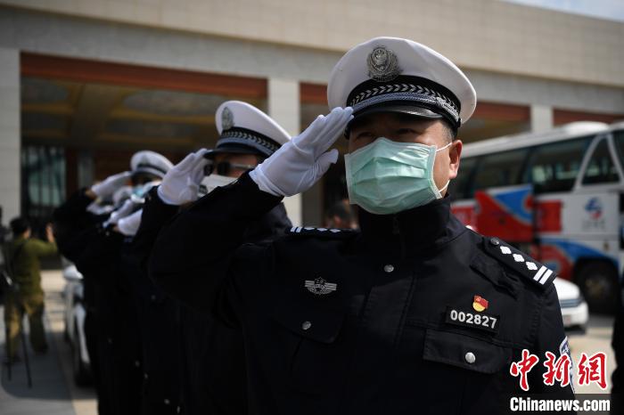 圖為交警們向醫(yī)療隊敬禮?！】灯?攝