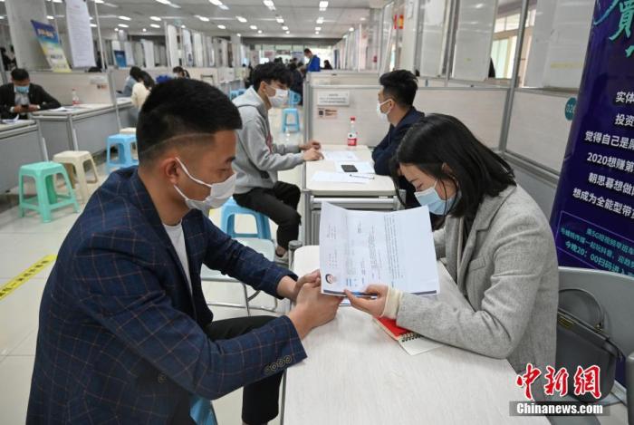 4月14日，招聘者在查看求職者簡(jiǎn)歷。<a target='_blank'  data-cke-saved- >中新社</a>記者 王剛 攝