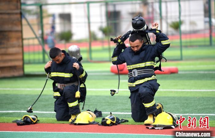 新消防員進(jìn)行穿戴空呼器展示?！⒅铱?攝