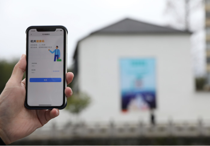 在浙江省杭州市臨安區(qū)天目山鎮(zhèn)，一名居民在“杭州健康碼”海報(bào)上掃碼申領(lǐng)個(gè)人二維碼。新華社發(fā)