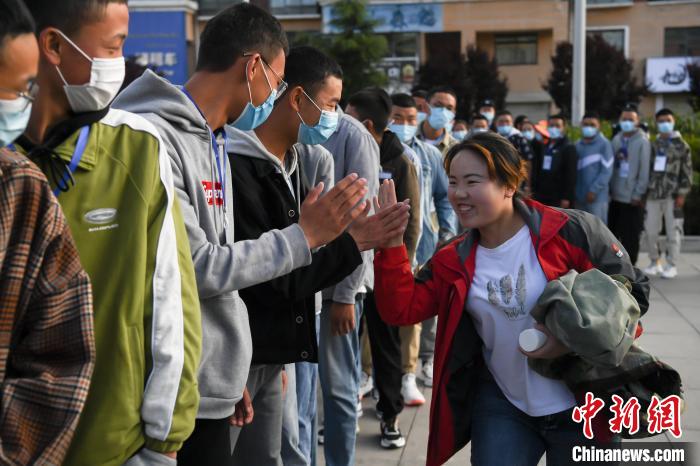 7月7日，拉薩三高考點外，領(lǐng)隊老師與考生擊掌鼓勁加油。　何蓬磊 攝