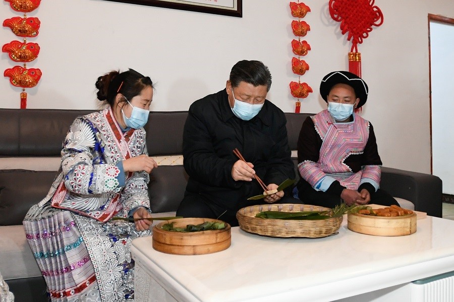 2021年2月3日下午，習(xí)近平在貴州畢節(jié)市黔西縣新仁苗族鄉(xiāng)化屋村苗族村民趙玉學(xué)家，同一家人邊聊家常邊制作當(dāng)?shù)貍鹘y(tǒng)節(jié)日食品黃粑。新華社記者 李學(xué)仁 攝